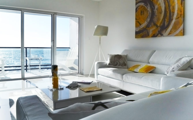 Le salon vu depuis l'entrée, la baie vitrée ouverte sur la mer
