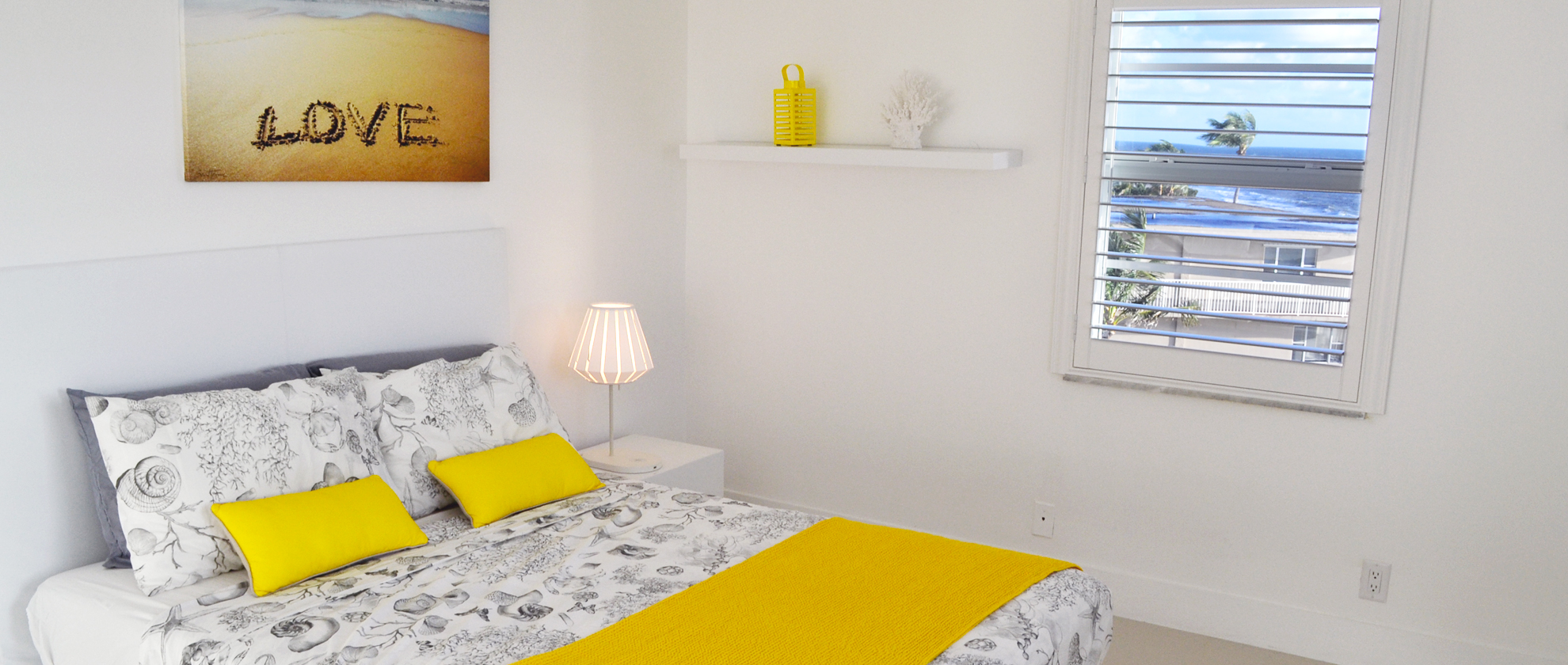 Chambre lumineuse avec vue sur les palmiers et la mer